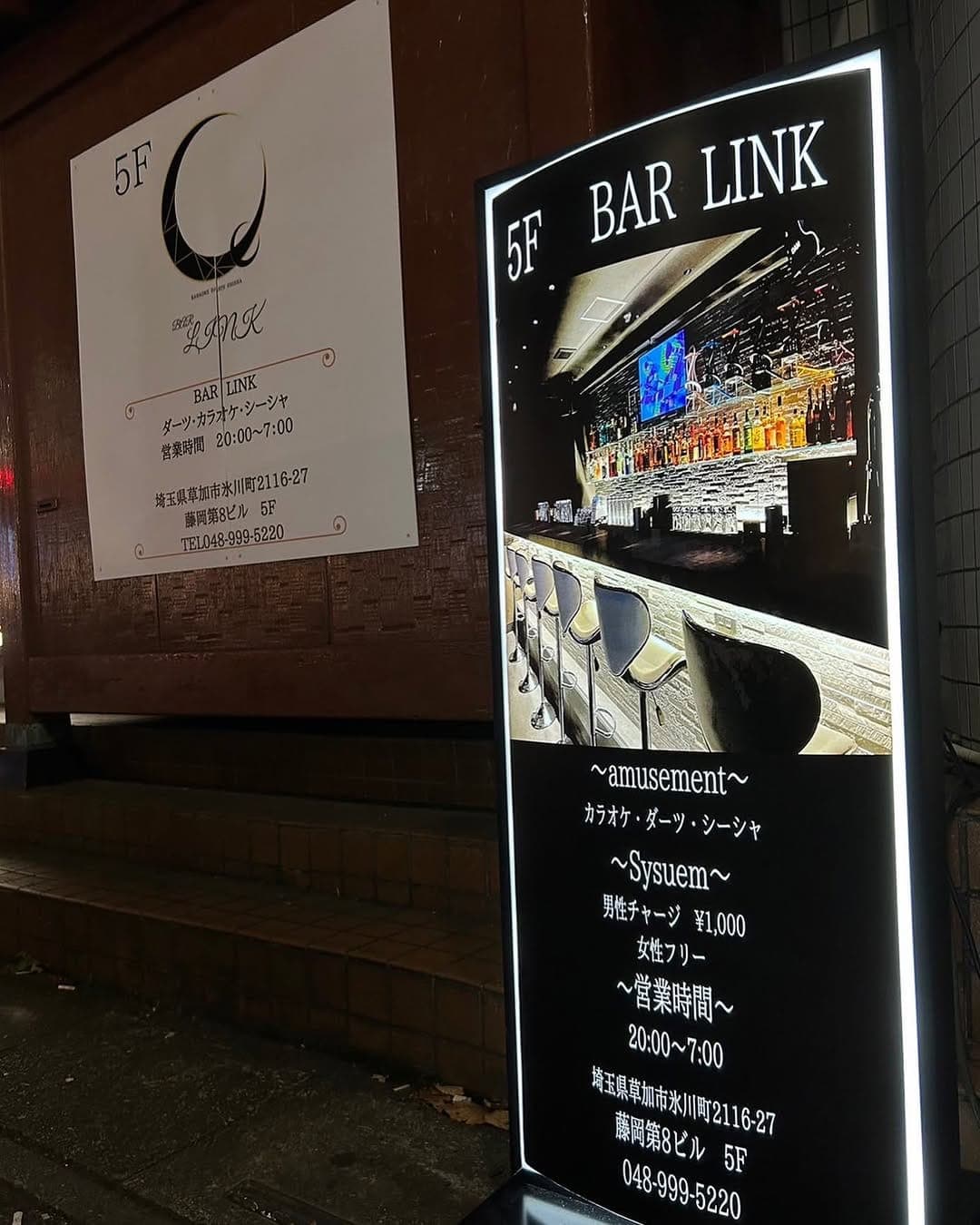ビル下の店の看板。カウンターの写真入り(2022年12月の投稿・営業時間は旧表記)