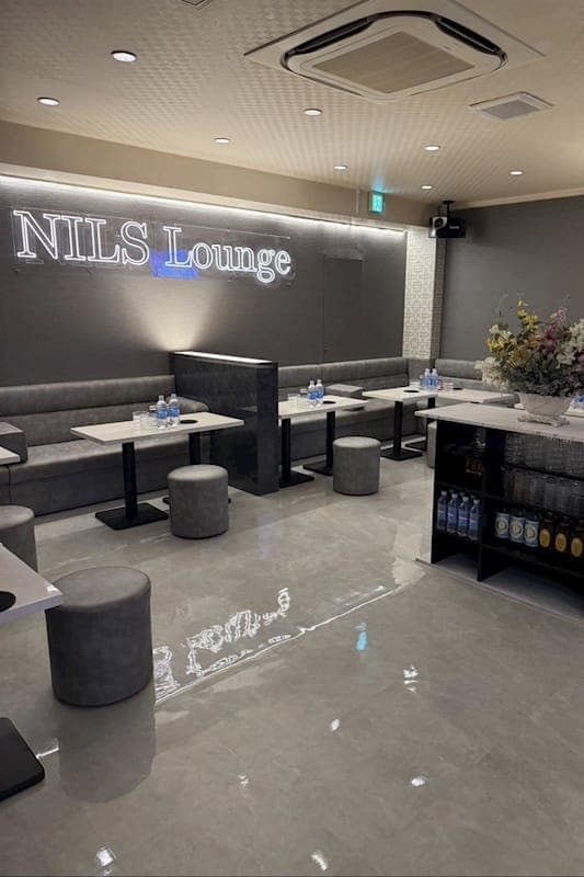 NILS Lounge の店内全景。大理石調の床とテーブル席